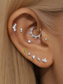 14K solid gold simple lightning bolt ear piercing stud shown on a model's ear with other jewelry.