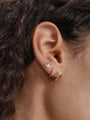 14K solid gold trio marquise ear piercing stud with cubic zirconia, worn in earlobe.