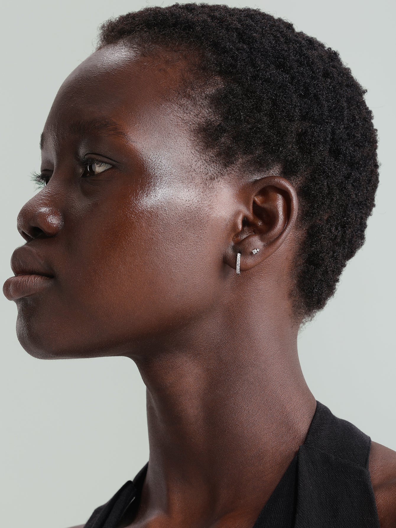 14K solid gold hoop earring with sparkling cubic zirconia worn on ear alongside a small cubic zirconia stud.