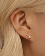 18k gold-plated ascending cubic zirconia stud earring on woman's ear. Hypoallergenic.