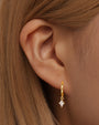 Kosiner 18k gold plated hypoallergenic hoop earring with quadrilateral cubic zirconia pendant on model.
