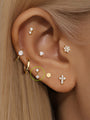 14K solid gold mini pendant stud earring with two prong-set cubic zirconia stones, flat back closure, shown on earlobe.