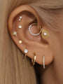 14K solid gold stud earring with white opal and prong setting, styled in an ear stack.