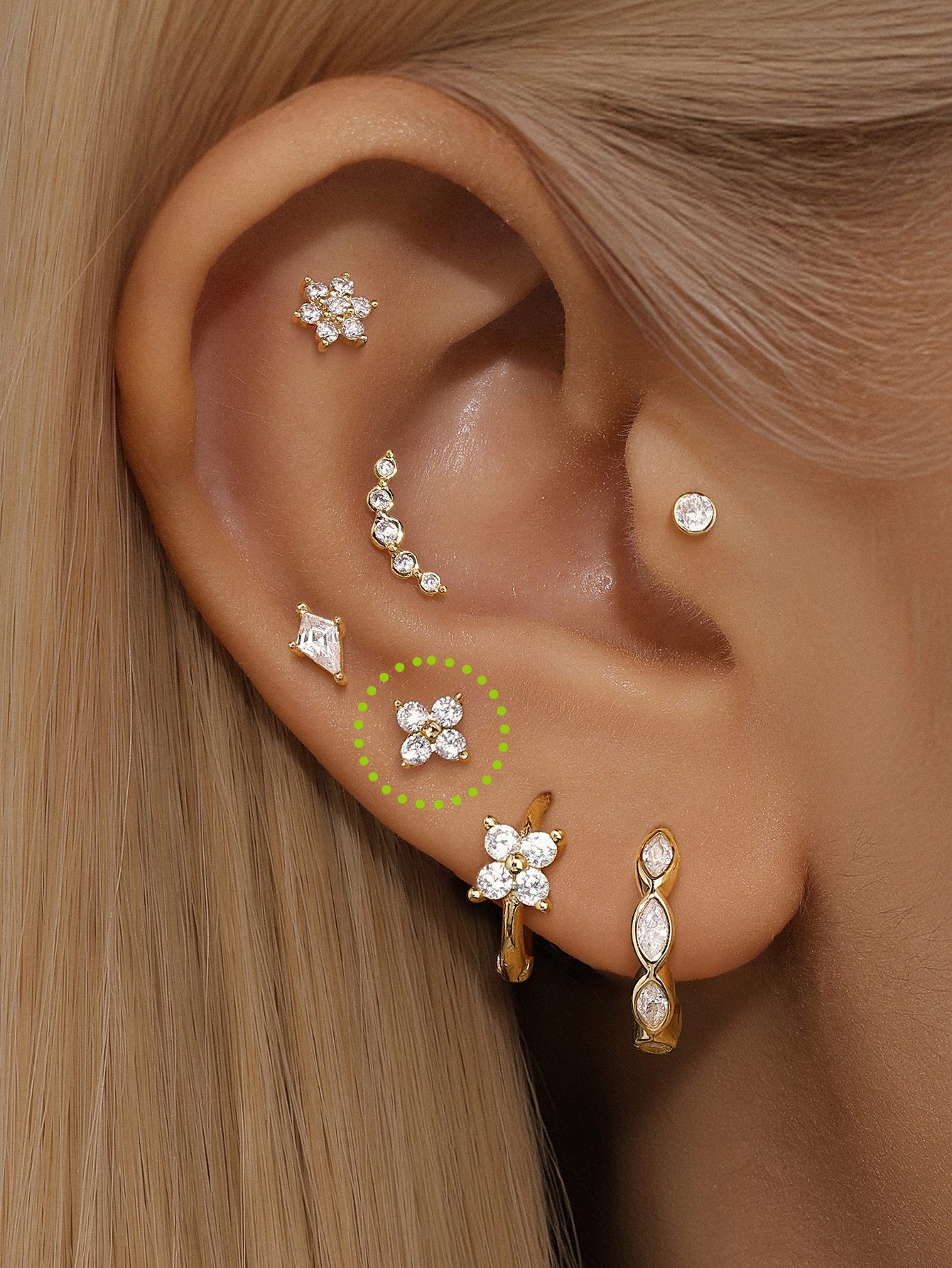14K solid gold sparkle flower piercing stud with clear cubic zirconia and flat back post styled on ear.