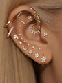 14K solid gold curved ear stud with three clear cubic zirconia pave stones, shown on ear piercing.