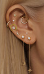 14K solid gold star stud earring with cubic zirconia, flat back labret post, shown styled on an ear piercing.