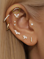 14K solid gold pave crescent moon ear piercing stud with five clear stones, styled on ear with multiple piercings.