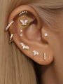 14K solid gold butterfly piercing stud with AAAAA cubic zirconia, styled on a human ear.