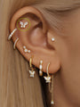 14K gold butterfly piercing stud with marquise cubic zirconia on ear. 18G flatback labret styled in ear stack.