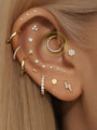 14K solid gold hoop earring with pave cubic zirconia crystals on a human ear.