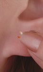 Layered ear stacking look with KOSINER rainbow light series piercing jewelry, featuring colorful baguette flat back studs for multi-position helix, tragus and lobe styling