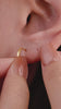 Edgy layered full ear stacking look featuring KOSINER Prism sparkle rivet spike dangle flat back helix stud, matched matching spike drop piercings, sunburst rook hoop, gold huggie lobe hoops, sharp modern geometric cartilage ear styling