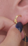 Angled view of KOSINER Rising Star gold-plated chain hoop with clear stones, an eight-pointed star and a hanging chain loop