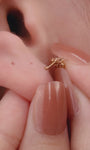 Stylish personalized full ear stacking look featuring KOSINER Prism chain pendant daith clicker hoop, paired triple spike drop lobe studs, marquise flat back helix stud, leaf shape cartilage piercing, delicate layered modern ear styling