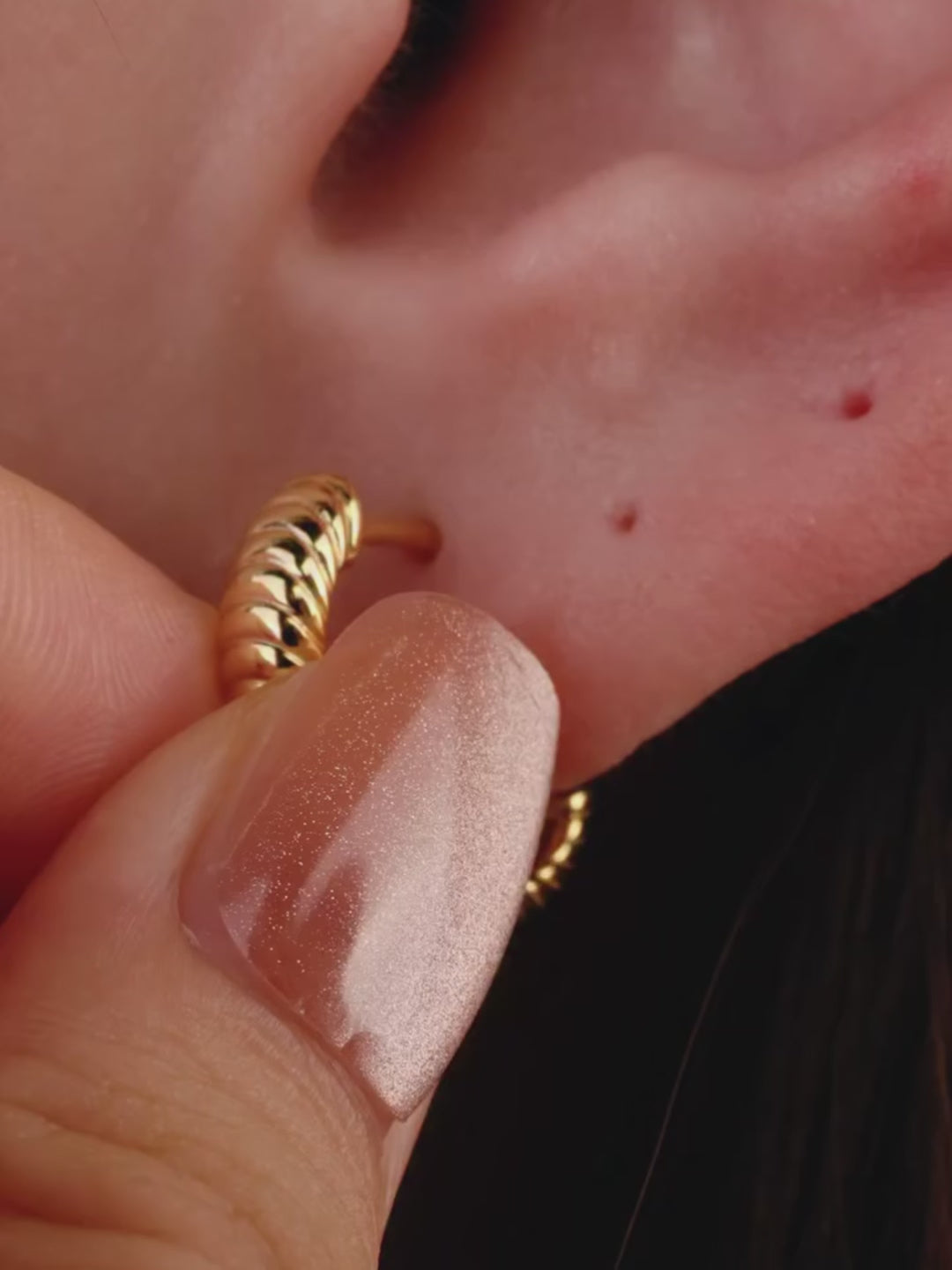 Elegant curated ear styling with KOSINER Étoile quadrilateral textured flat back stud on earlobe, matched with sunburst, leaf, triangular gem studs and gold hoop rings, refined minimalist multi-piercing daily look