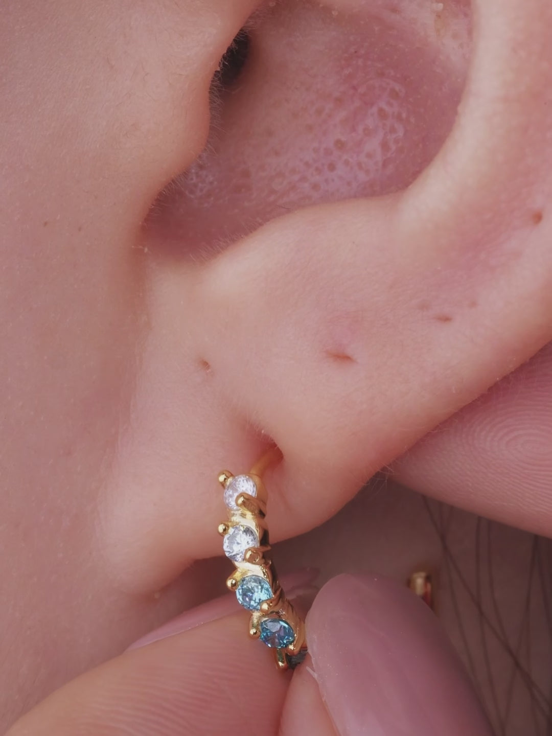 Layered ear stack styling with KOSINER aquamarine gem collection, marquise floral silver clicker hoop matched with ocean themed tiny cartilage piercings