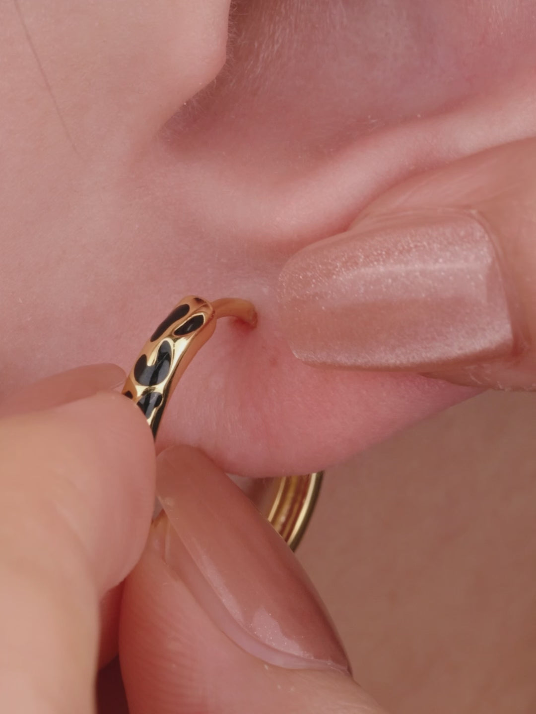 Refined layered full ear stacking look with KOSINER Puzzle dual-tone black enamel cz sterling silver hoop earring, paired tiny cz studs, geometric triangle two-tone studs, minimalist gold hoops, sleek contemporary everyday ear styling