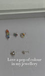 Ear stack close-up with KOSINER rainbow hollow halo flat back stud, matched with chain pendant and geometric floral cartilage piercings for multi-position lobe helix styling