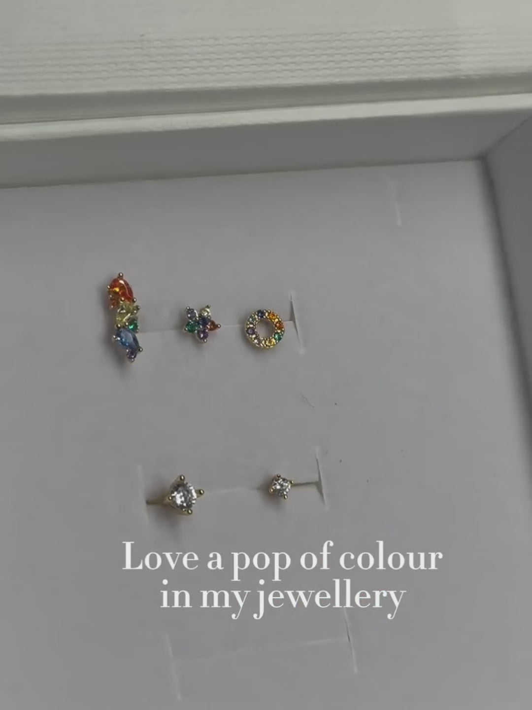 Ear stack close-up with KOSINER rainbow hollow halo flat back stud, matched with chain pendant and geometric floral cartilage piercings for multi-position lobe helix styling