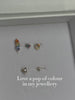 Ear stack close-up with KOSINER rainbow hollow halo flat back stud, matched with chain pendant and geometric floral cartilage piercings for multi-position lobe helix styling