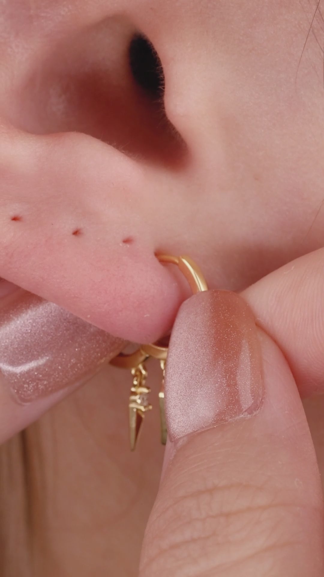 Edgy layered full ear stack styling with KOSINER triple rhombus spike drop hoop, paired pointed spike studs, starburst rook hoop, dangle helix piercings, minimalist punk geometric ear stacking aesthetic for lobe & helix piercings