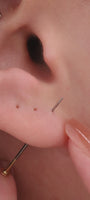 Stylish personalized full ear stacking look featuring KOSINER Prism chain pendant daith clicker hoop, paired triple spike drop lobe studs, marquise flat back helix stud, leaf shape cartilage piercing, delicate layered modern ear styling